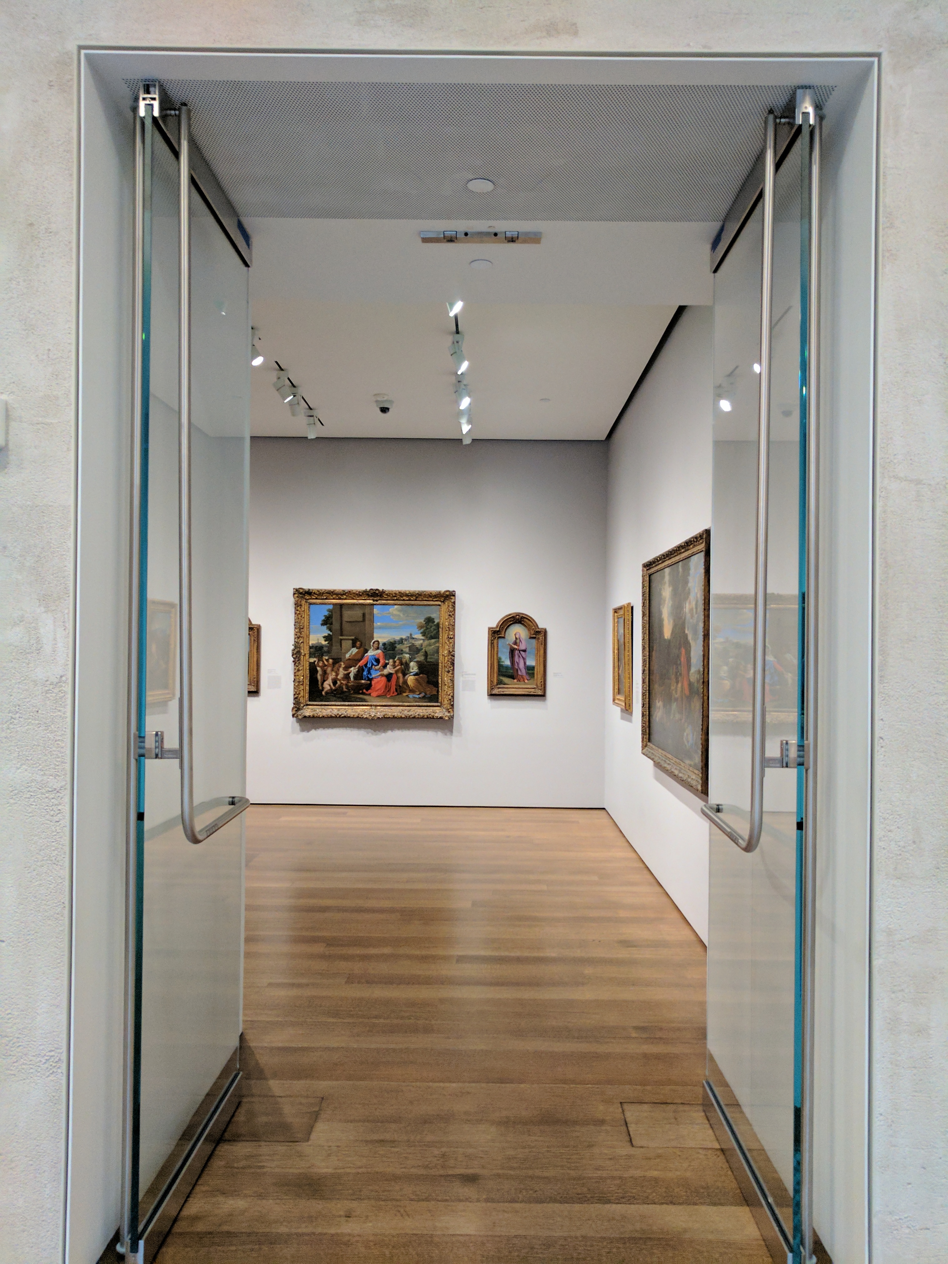 An image of Christian paintings through a door in the Harvard Art Museum.
